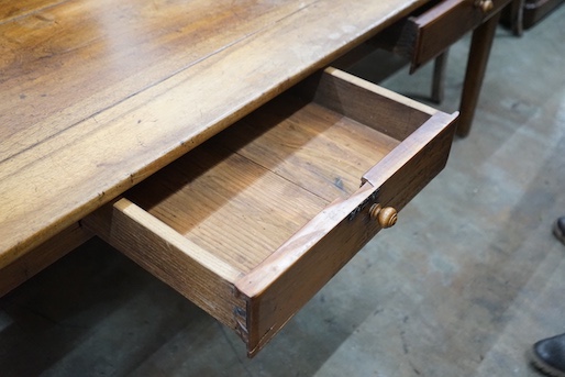 An early 19th century French rectangular fruitwood kitchen table fitted two drawers, length 201cm, depth 80cm, height 76cm